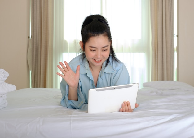 Young maid opening curtains in hotel room