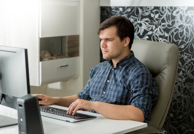 Young male adult is woking at his desk