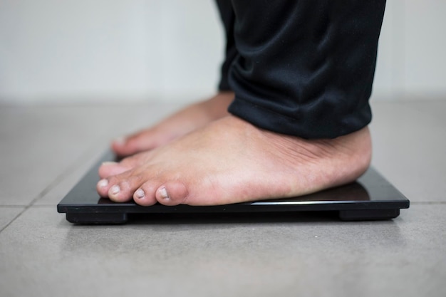 Young male bare feet stand on the scale