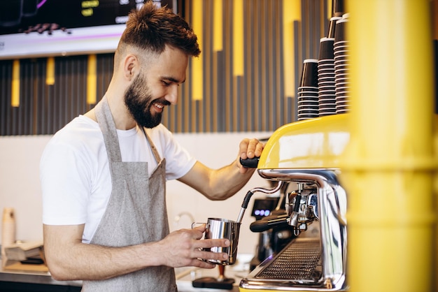 Giovane barista maschio che lavora in una caffetteria