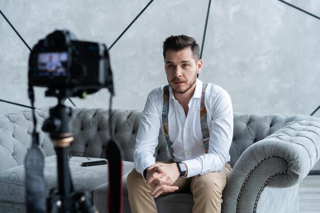 Photo young male blogger recording video at home.