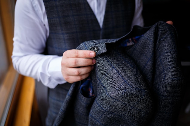 Young male businessman is dressing a stylish suit for an important meeting. Clothing for an adult man