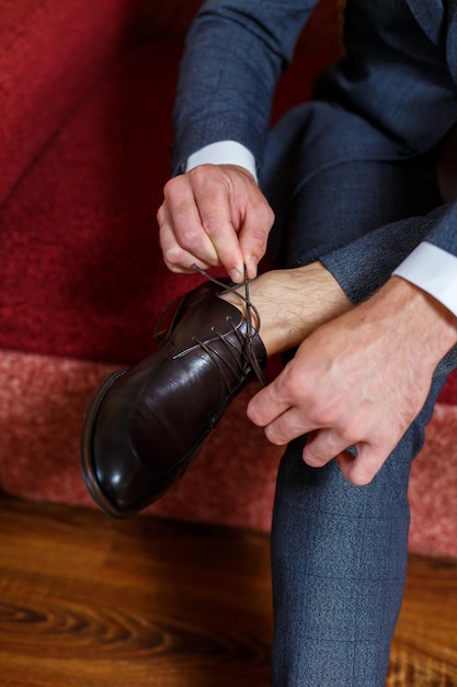 Young male businessman puts on a shirt and a stylish suit before a meeting