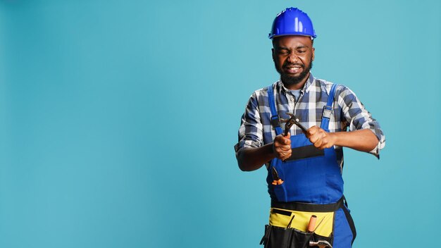 Young male carpenter tightening with spanner, using wrench tool to fix and clamp something. construction repairman with hardhat doing reconstruction work on camera, steel equipment