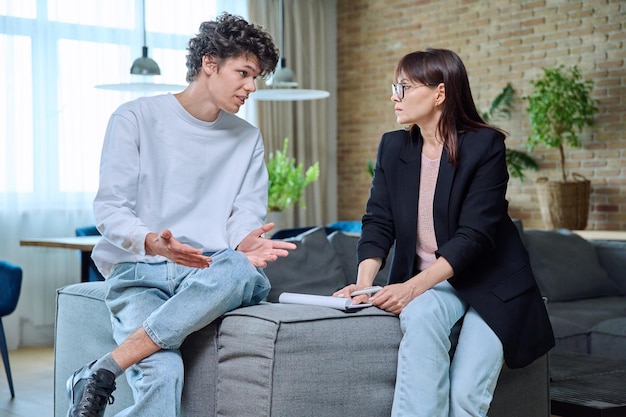 Young male communicates with female psychologist at therapy session in office