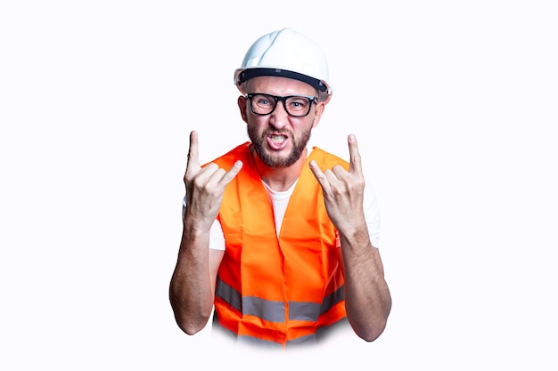 Young male construction worker showing rocker goat sign on light background