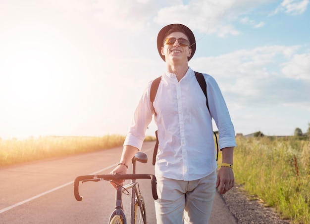 Young male cyclist walking by feet