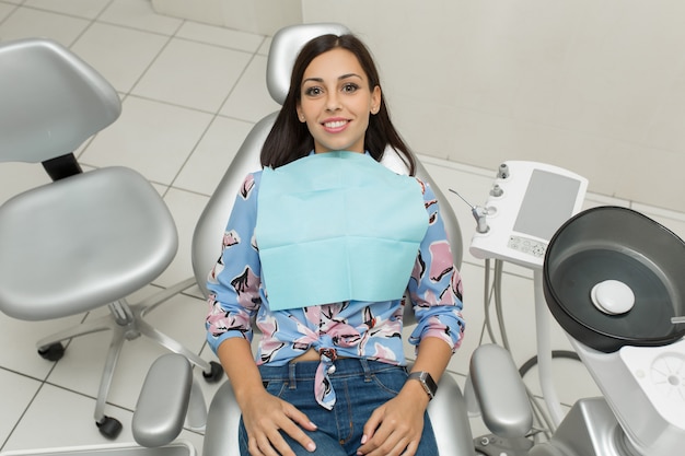 A young male dentist and happy female patient. Dentist office lifestyle scene. Doctor practice. Patient health care