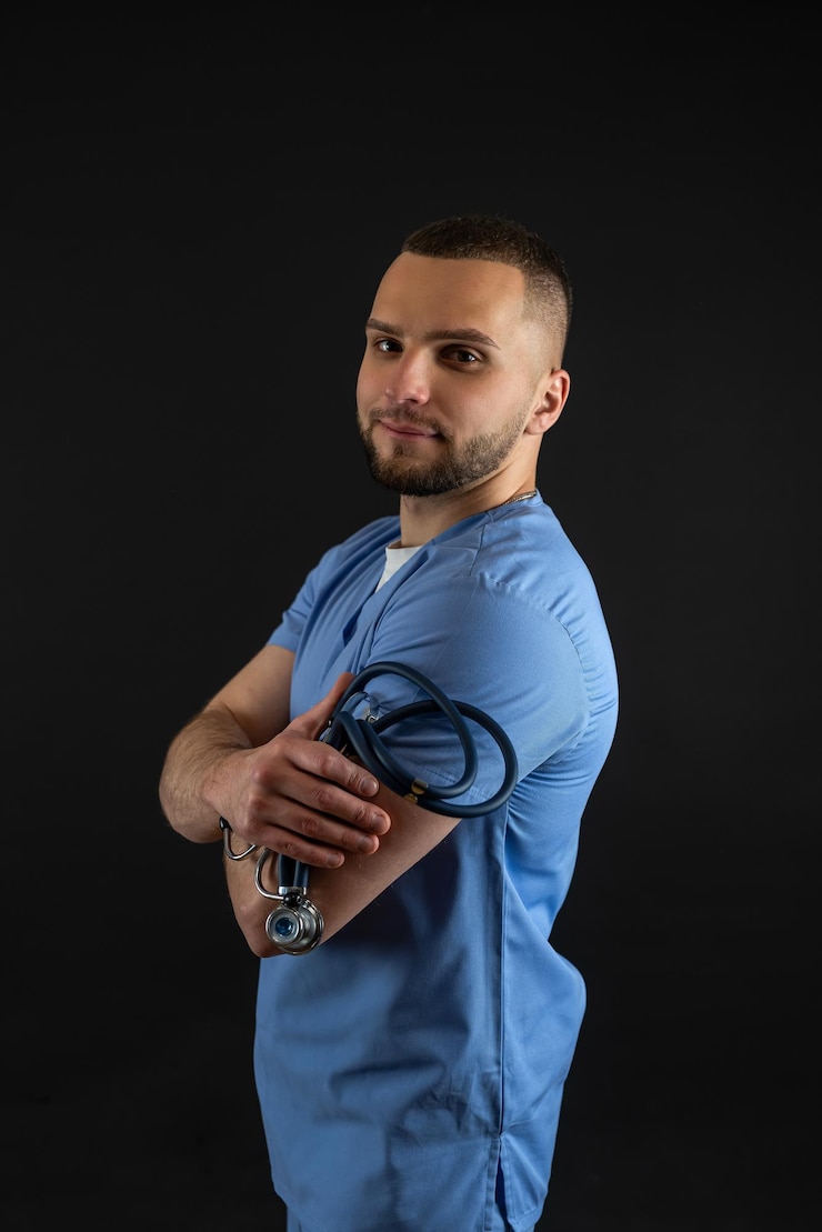 Photo young male doctor in blue uniform and stethoscope isolated
