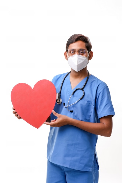 Young male doctor holding a beautiful red heart shape in hand