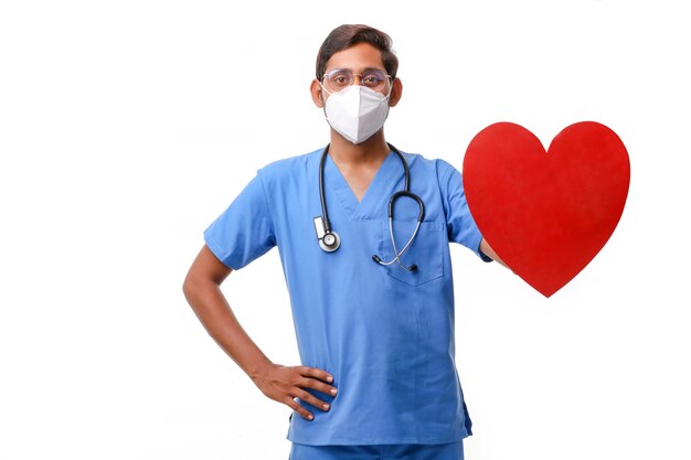 Young male doctor holding a beautiful red heart shape in hand