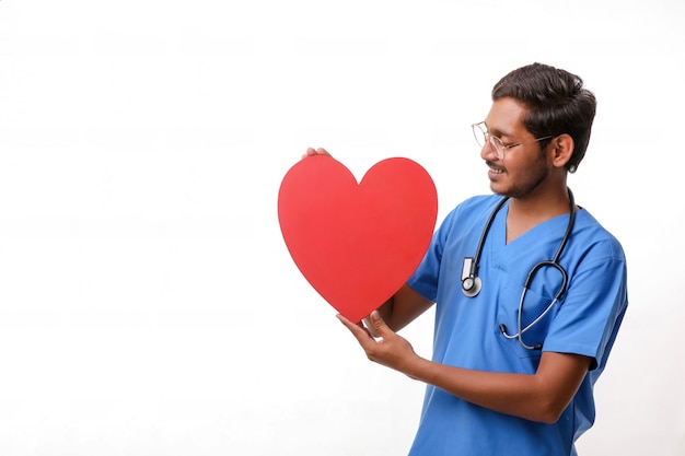 Young male doctor holding a beautiful red heart shape in hand