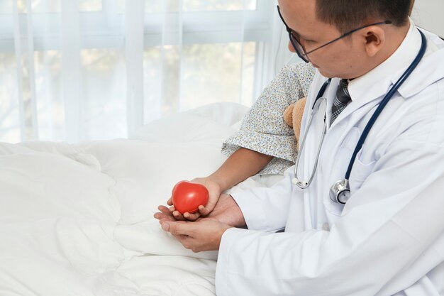 Young male doctor pediatrician checking girl