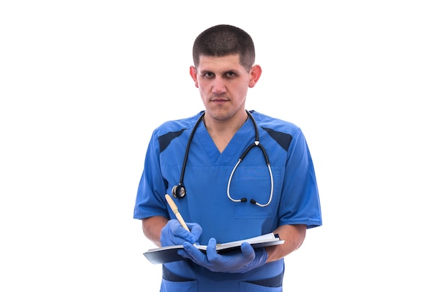Giovane medico maschio in uniforme con il documento di scrittura dello stetoscopio isolato