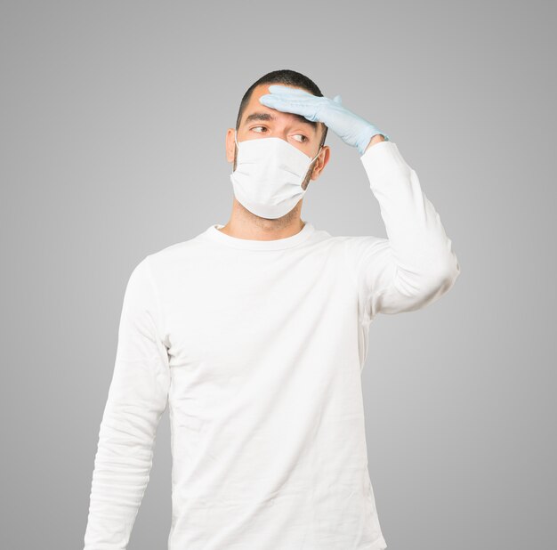 Young male doctor wearing mask and protective gloves