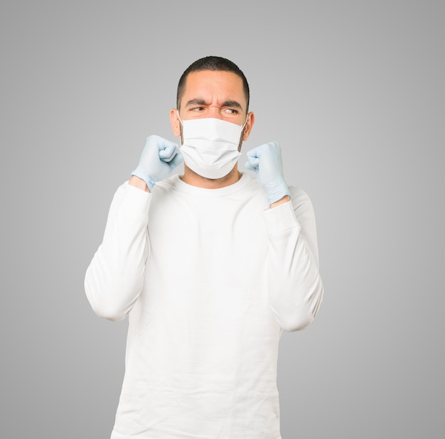 Young male doctor wearing mask and protective gloves