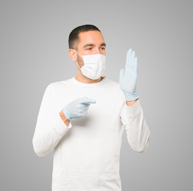 Young male doctor wearing mask and protective gloves