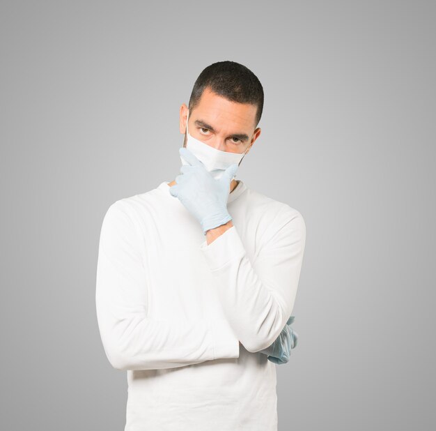 Young male doctor wearing mask and protective gloves