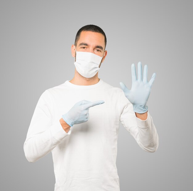 Young male doctor wearing mask and protective gloves