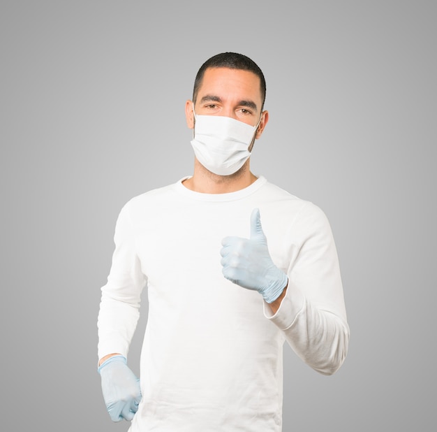 Young male doctor wearing mask and protective gloves