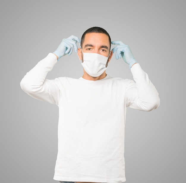 마스크와 보호 장갑을 착용하는 젊은 남성 의사