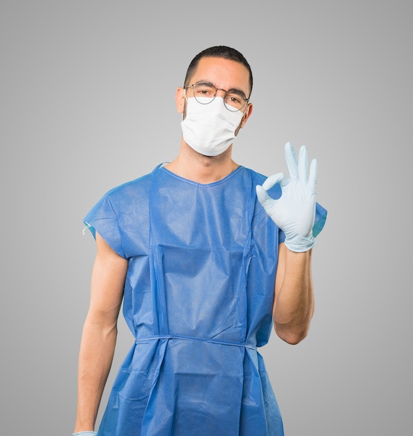 Young male doctor wearing mask and protective gloves