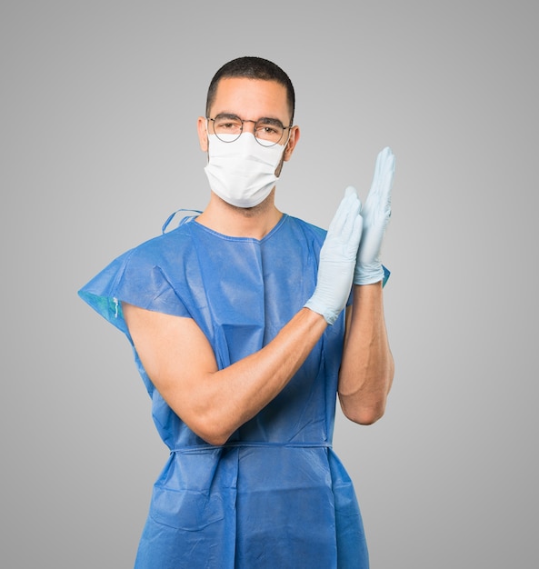 Young male doctor wearing mask and protective gloves