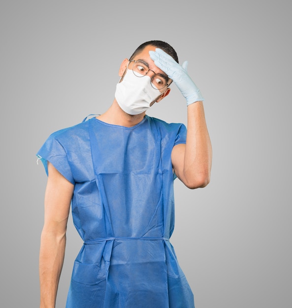 Young male doctor wearing mask and protective gloves