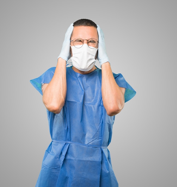 Young male doctor wearing mask and protective gloves