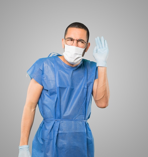 Young male doctor wearing mask and protective gloves