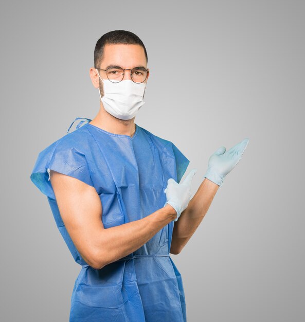 マスクと保護手袋を身に着けている若い男性医師