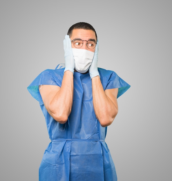 Young male doctor wearing mask and protective gloves