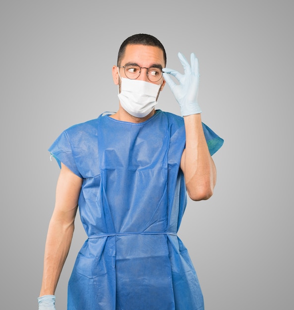 Young male doctor wearing mask and protective gloves