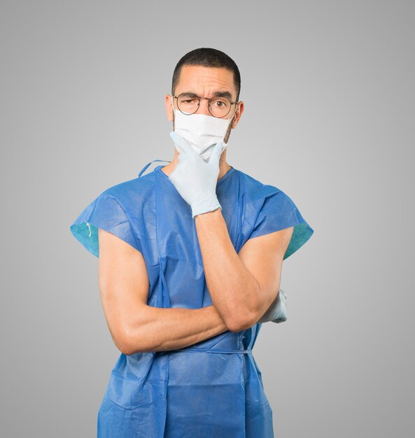 Young male doctor wearing mask and protective gloves