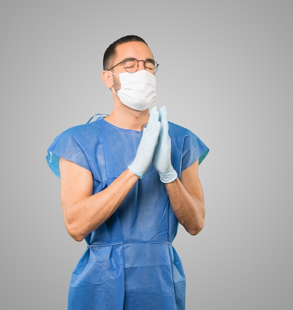 Young male doctor wearing mask and protective gloves