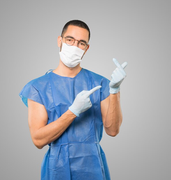 Young male doctor wearing mask and protective gloves