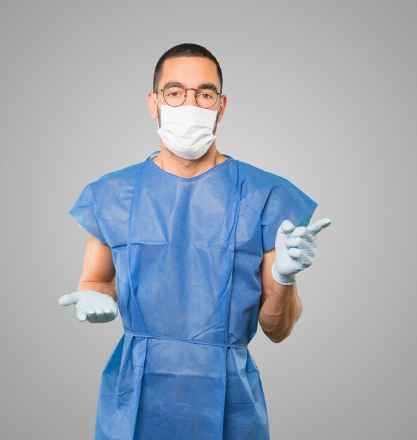 Young male doctor wearing mask and protective gloves