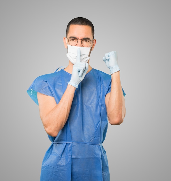 Young male doctor wearing mask and protective gloves