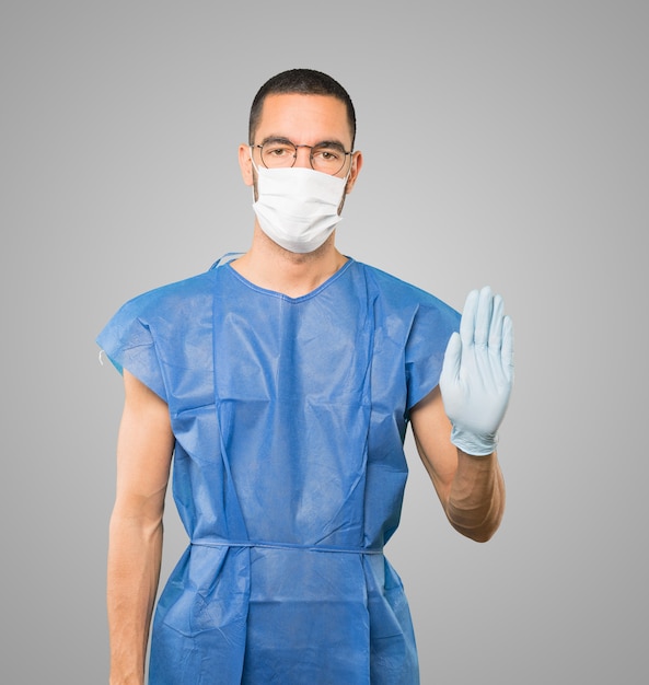 Young male doctor wearing mask and protective gloves