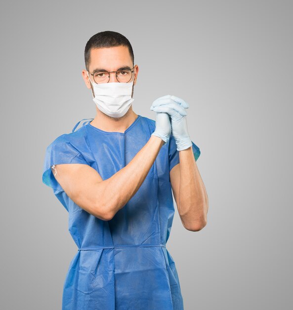 Young male doctor wearing mask and protective gloves