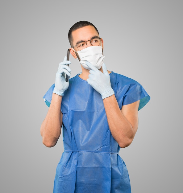 Young male doctor wearing mask and protective gloves