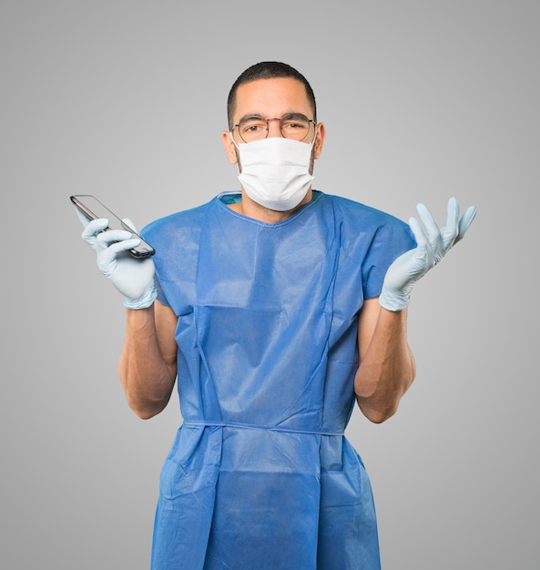 Young male doctor wearing mask and protective gloves