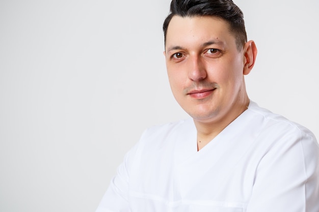 Young male doctor in a white surgical suit.Isolated on a white background