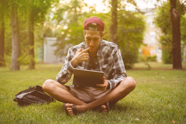 Young male freelancer working on a tablet and typing the text