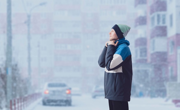 A young male guy wearing warm winter season jacket on a cold\
day