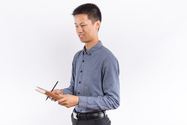 Young male hands holding notepad standing in front of white background