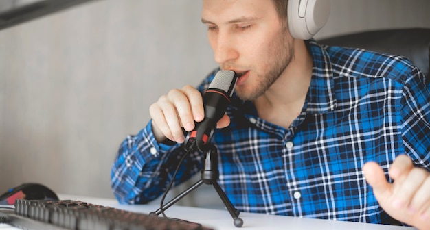 A young male handsome host recording podcast in the studio, streaming live