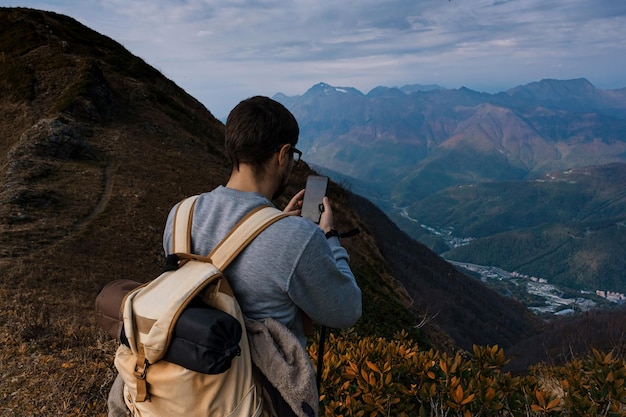 秋の山の若い男性のヒップスター