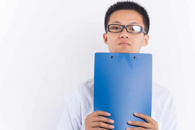 A young male holding a blue folder standing in front of white background