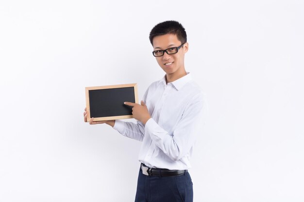 A young male holds a small blackboard in his hand